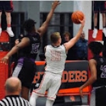 Boy's basketball players jumping for ball