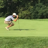 Male golfer lining up shot