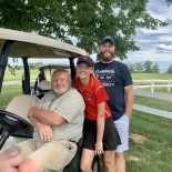 girl and guy with man on golf cart